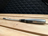 a butane lighter sitting on a cedar bench