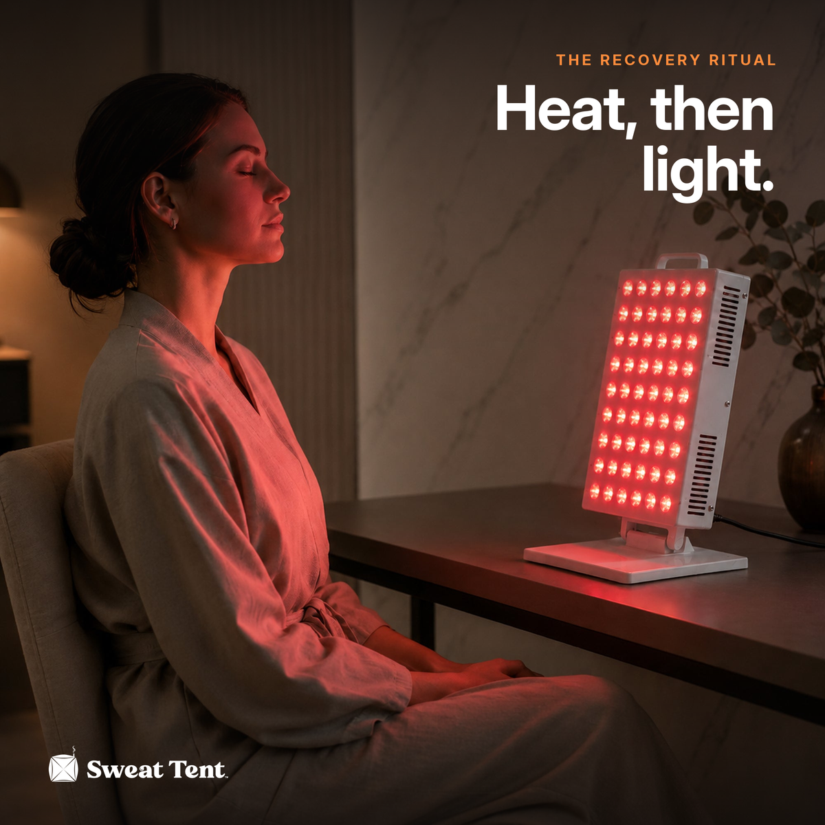 A woman relaxing at a desk with the SunPanel Mini red light panel switched on